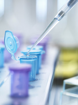 Pipetting drops of liquid into eppendorf tubes, side view