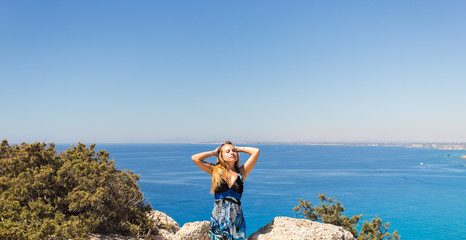 young beautiful caucasian female on a cliff above the sea