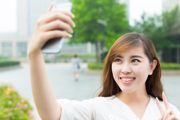Fototapeta premium young beautiful asian girl with phone in school
