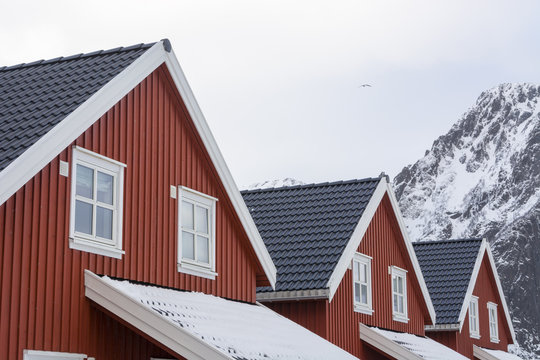 Detail of three houses and snow capped mountain, Svolvaer, Lofoten Islands, Norway