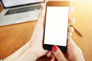 Close up shot of female hands holding smart phone with blank copy space screen for your text or information content.  Office worker surfing Internet on mobile phone in the office. Film effect