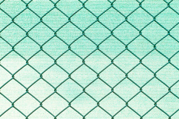 Fototapeta premium Grid metal wires on blurred green nylon background