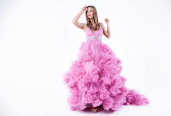 Portrait of young beautiful caucasian blonde in gorgeous pink dress on white background