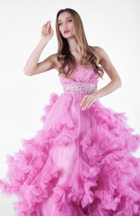 Naklejka premium Portrait of sexy young beautiful caucasian blonde in gorgeous pink dress on white background