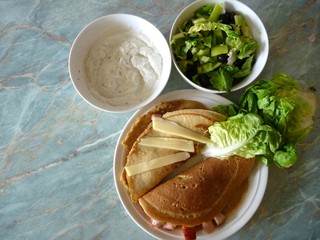 filled pancakes served with green salad and sauce