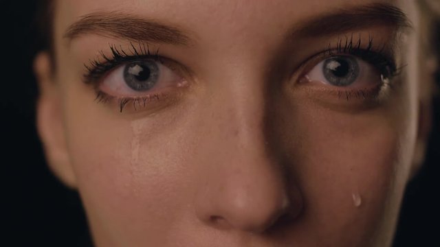 Closeup view of face of SAD Young Woman Crying and having problems with private life. Girl in depression because of home violence. She is disappointed. Tears on face. ideal for social ads. 4K video