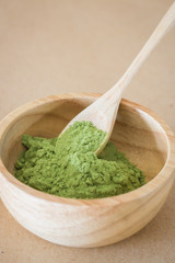 Premium green tea powder in wooden bowl