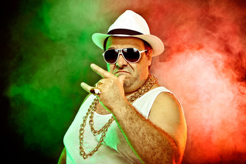 italian funny mafia boss rapper with undershirt and sunglasses on smoky background - obrazy, fototapety, plakaty