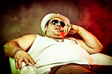 italian funny mafia boss rapper with undershirt and sunglasses on smoky background