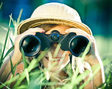 beautiful young explorer girl with hat and binocular at park