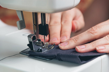 Hands of young girl on sewing machine