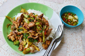 spicy stir-fried chicken innards with basil leaves on rice