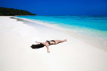 Fototapeta na wymiar Enjoyment. Beautiful brunette lying On Tropical Beach. Sexy biki