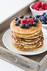 Pancakes with blueberries and raspberries on tray
