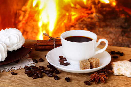Coffee with spices and marshmallows on a background of a burning