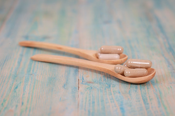Capsules of herbs on spoon. healthy eating for healthy living.