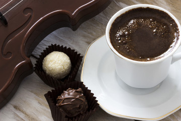 Turkish coffee, truffle chocolate and violin on wooden table