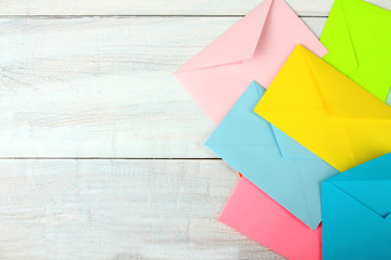 colored envelopes for letters closeup on white wooden backgroundw