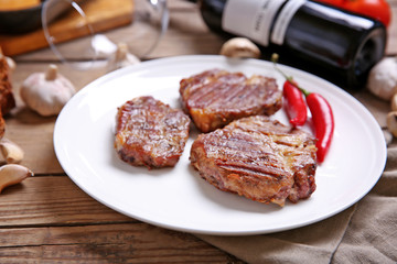 Roasted beef fillet on plate, on wooden background