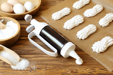  Meringues and ingredients on a sheet of parchment and culinary