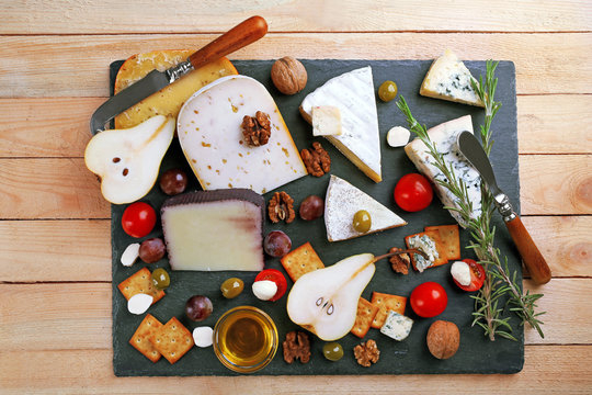 Different kinds of cheese on wooden background