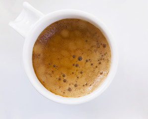 Top view of a cup of coffee on white plate