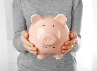 Woman holding piggy bank in hand. Financial savings concept