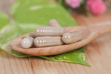 Capsules of herbs on spoon. healthy eating for healthy
