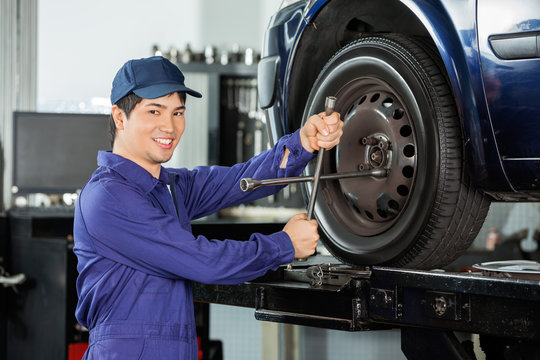 Confident Mechanic Fixing Car Tire