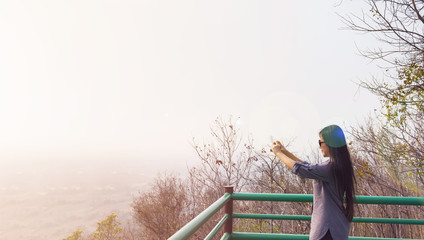 Asian lady take picture from mobile on highland top view seeing