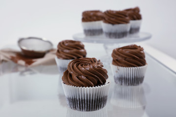 Chocolate cupcakes on light glass background