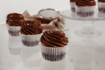 Chocolate cupcakes on light glass background, close up