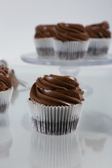 Chocolate cupcake on light glass background, close up