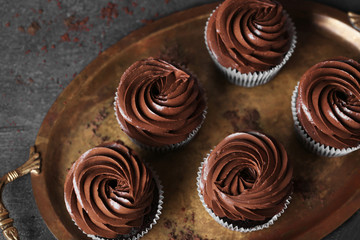 Chocolate cupcakes on a tray over grey background, close up