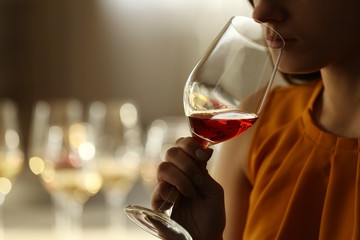 Woman sniffing red wine in a glass, close up