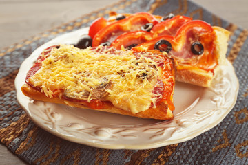 Hot pizza baguettes with salami, ham and cheese on wooden table