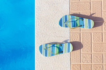 Pair of slippers at edge of swimming pool
