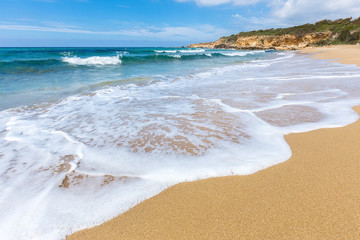 Sandy beach sea waves and mountain at coast