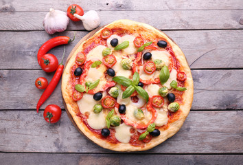 Delicious pizza with cheese and vegetables on wooden background