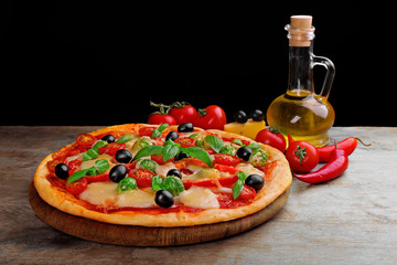 Delicious pizza with cheese and vegetables on black background