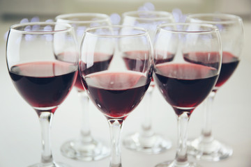 Glasses of red wine on white table closeup