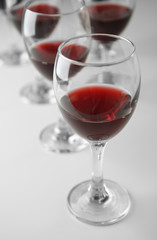 Glasses of red wine on white table closeup