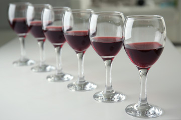Glasses of red wine on white table closeup