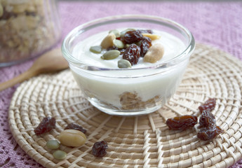 Yogurt with granola and pumpkin seeds, nuts and raisin on top
