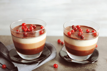 Delicious dessert with rowan in glass on table