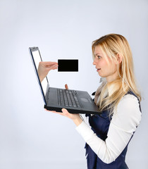 Surprised woman holding a laptop and hand with business card