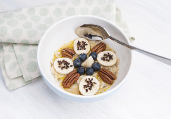 Porridge with banana, nuts, topping and chocolate crumbs
