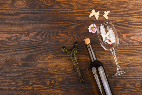 Wineglass and bottle with decorative flowers and butterflies