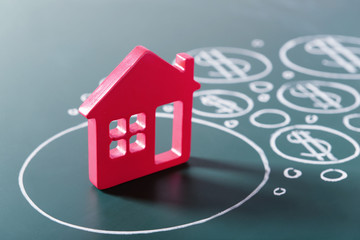 House figure and painted dollar symbols on chalkboard,closeup