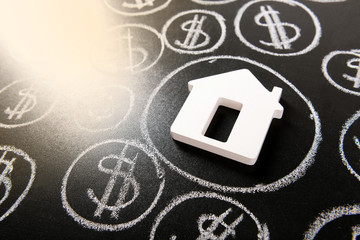 House figure and painted dollar symbols on chalkboard,closeup